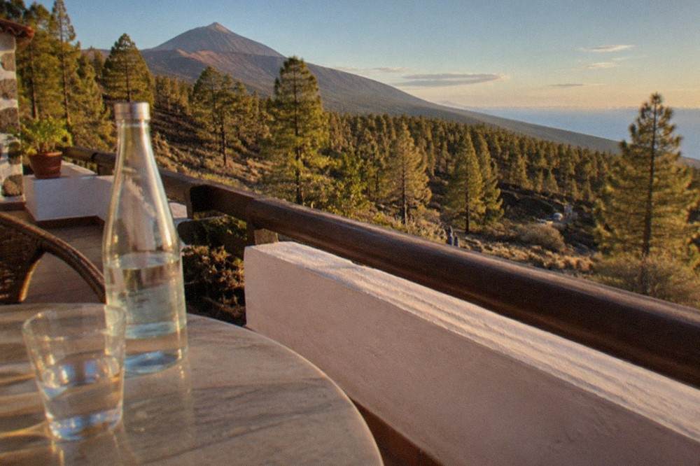Bottled water and a glass on a sunny apartment terrace overlooking the sea