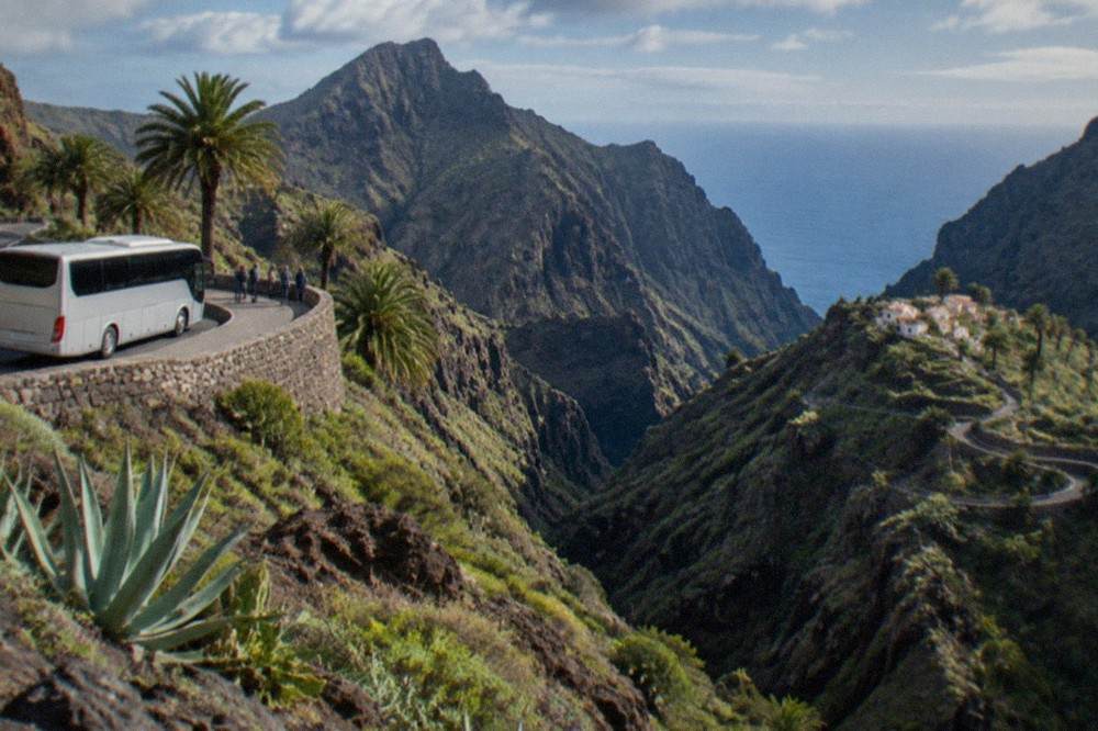 An island bus at a stop on a coastal road in South Tenerife