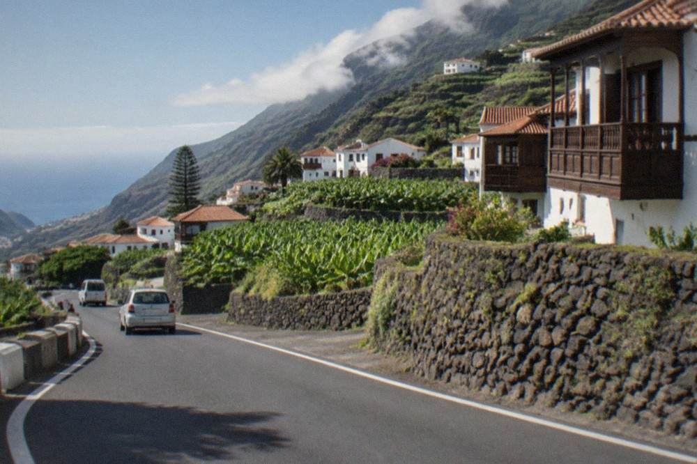 A coastal road winding between cliffs and the sea in western Tenerife