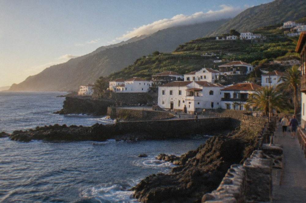 White buildings in Garachico rising up a hillside under a clear blue sky