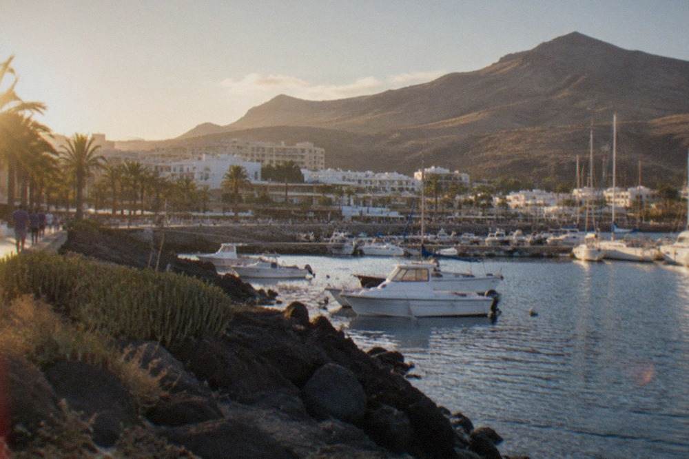 A harbour town on the Tenerife coast with boats moored along the waterfront