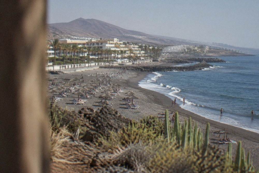 A view over Costa Adeje beach towards the Atlantic with parasols and sunloungers along the sand