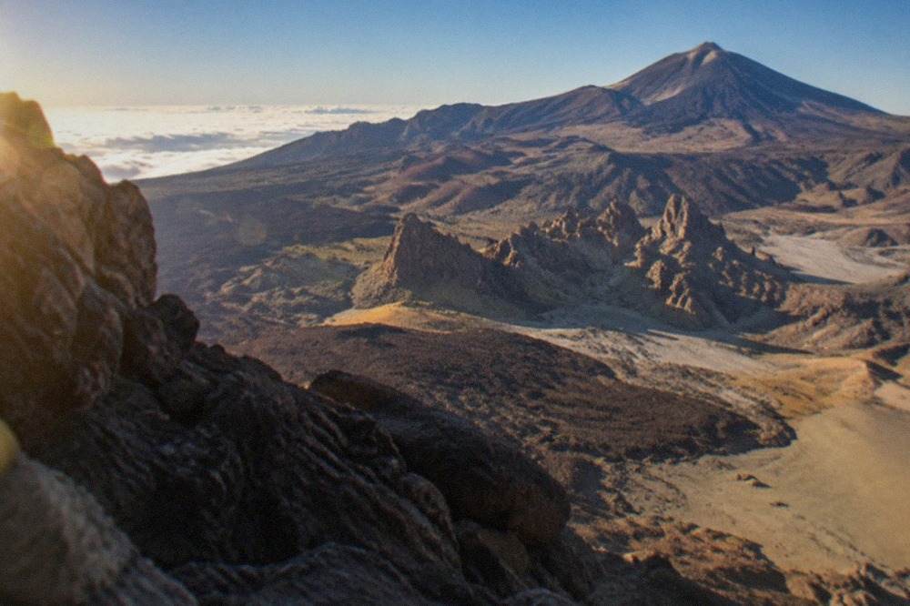 Aerial view of a volcanic Canary Island coastline with black sand beaches and blue Atlantic water