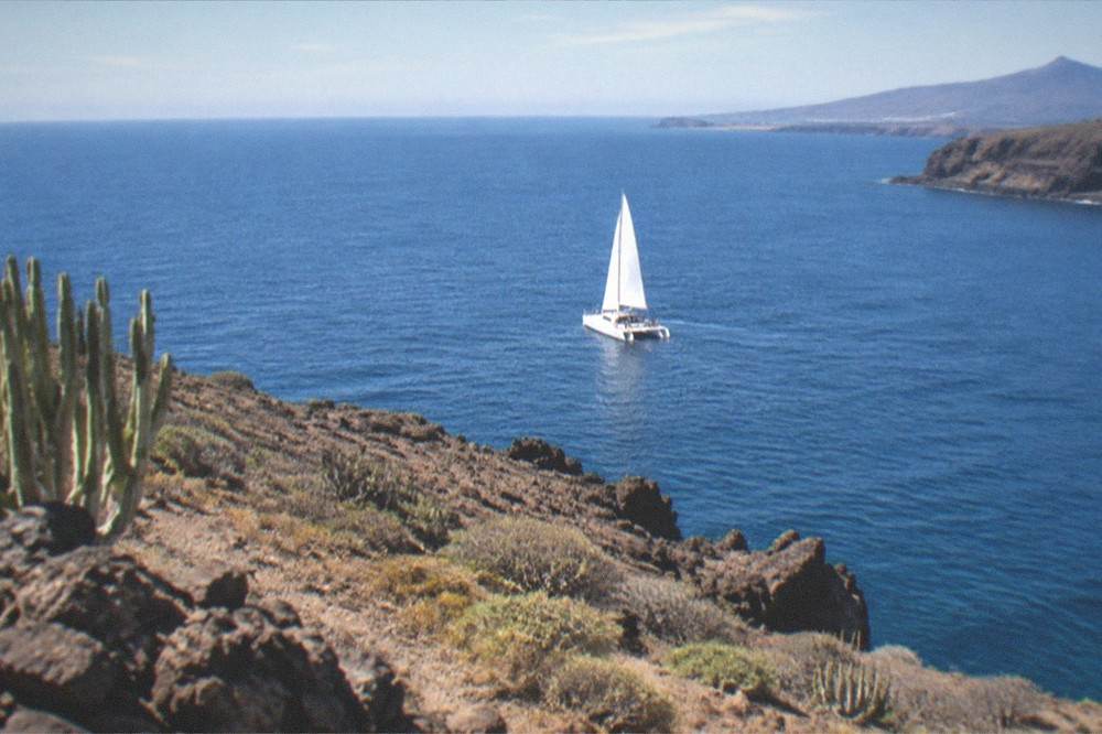 A catamaran sailing on open water near the south-west coast of Tenerife