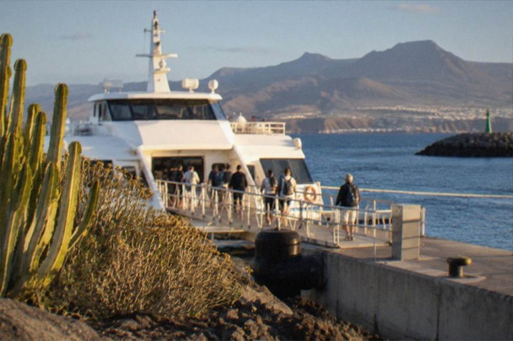 A ferry at a harbour with mountains visible across the water