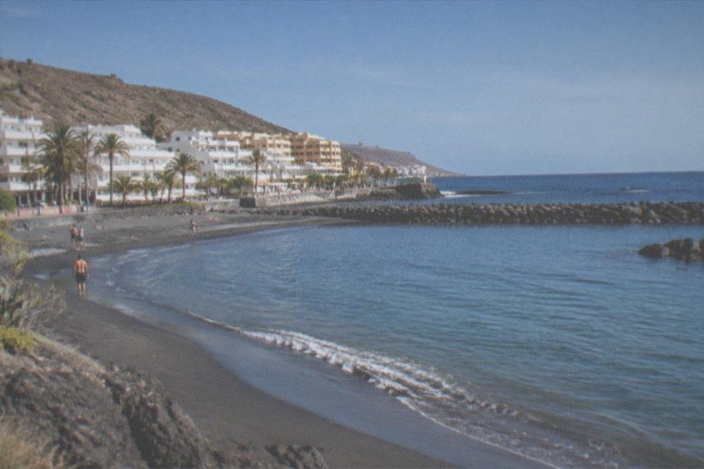 A sheltered sandy beach with breakwaters and calm shallow water