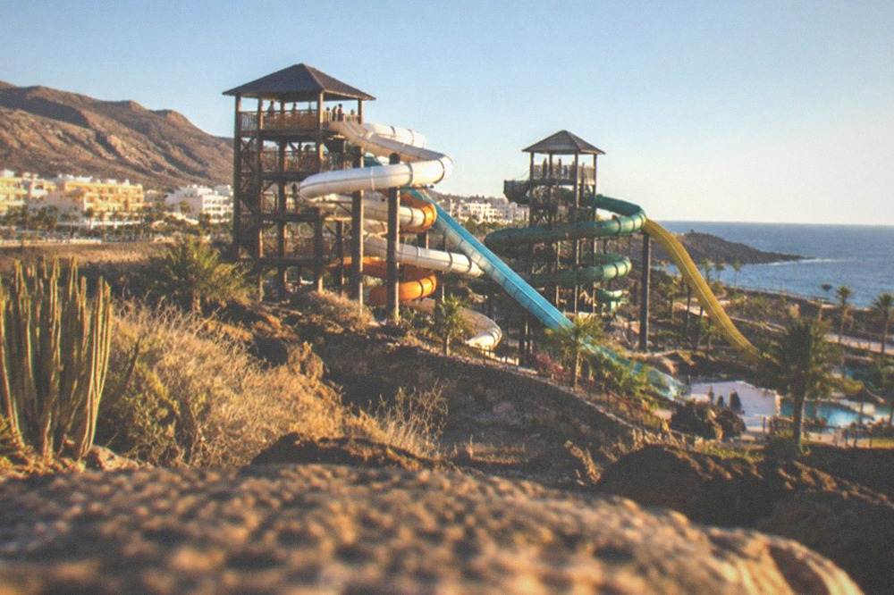 Water park slides and towers under a clear sky in Costa Adeje