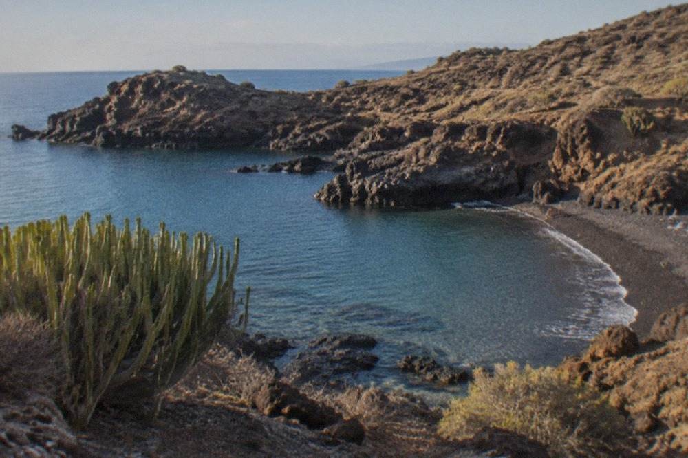 A small sheltered cove on the Adeje coast with clear calm water and rocky headlands