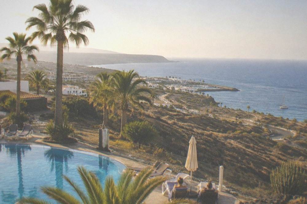 Quiet resort pool terrace with palm trees in the evening light