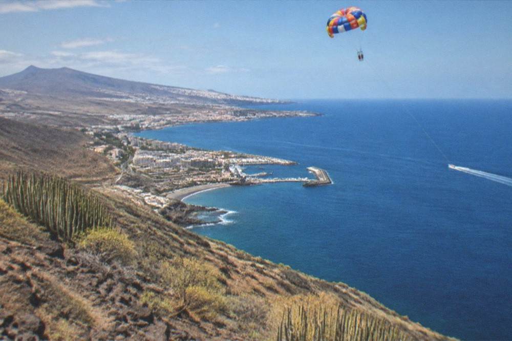 Parasail parachute high above the blue sea and coastline of south Tenerife