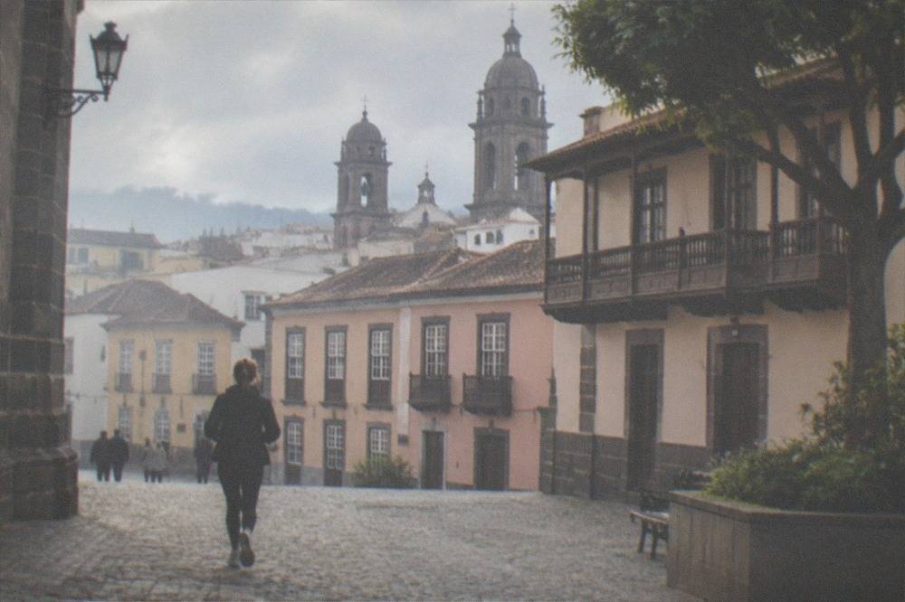 A quiet cobbled square in La Laguna with church towers behind rooftops