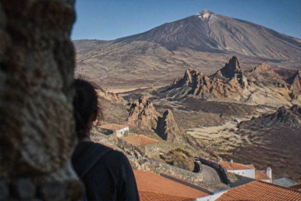 Hillside town rooftops with Teide summit above in clear light
