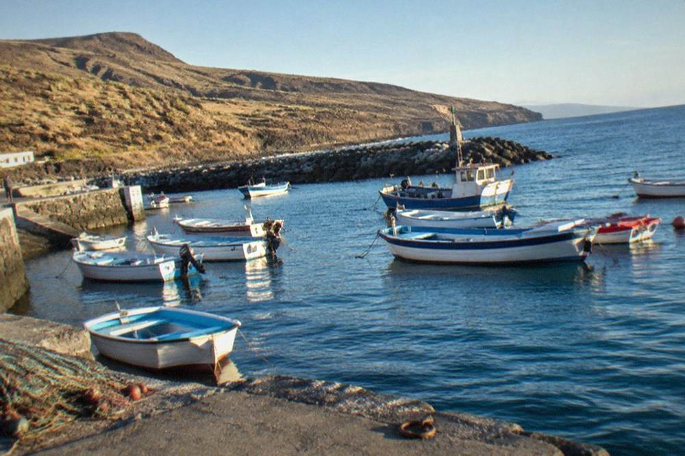 Fishing boats and a small stone jetty in a harbour on the south coast of Tenerife