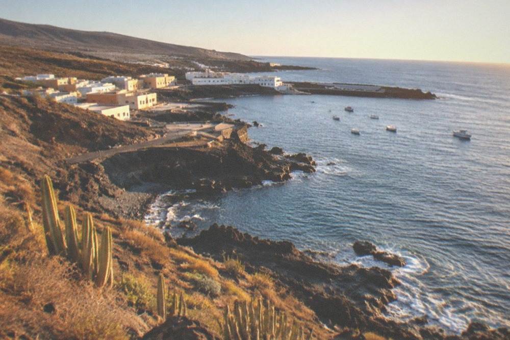 A sunny south coast shoreline with calm blue water and a clear sky