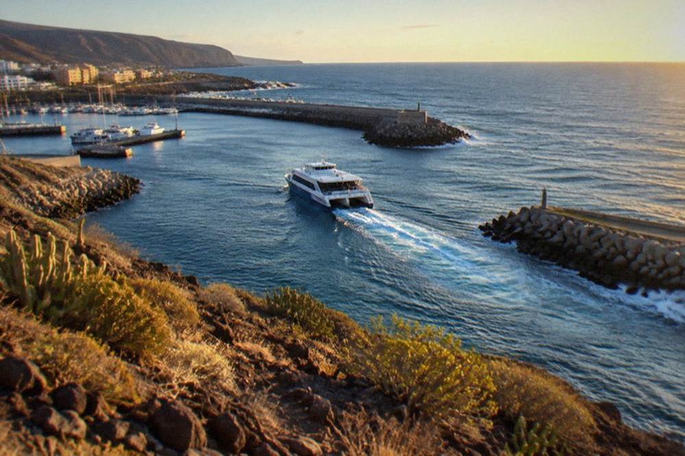 A catamaran leaving Los Cristianos harbour in the morning