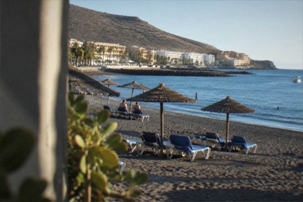 Sun loungers on a south Tenerife beach with calm sea in the morning