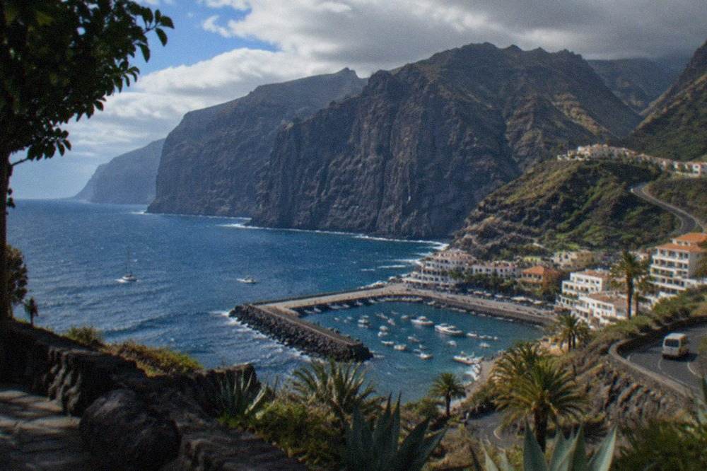 The tall dark cliffs of Los Gigantes rising above a small harbour town on the Tenerife coast