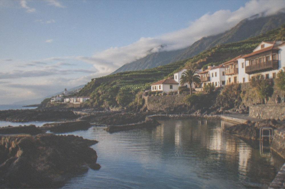 Natural rock pools filled with seawater beside a historic waterfront town