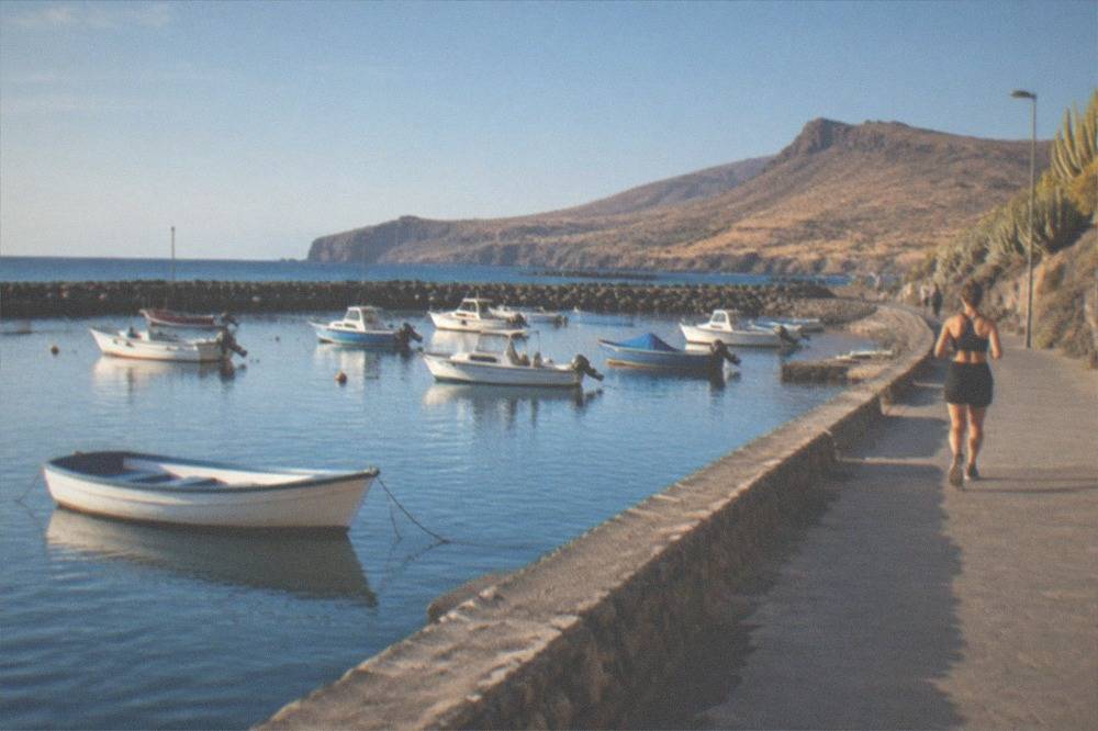 Small boats moored in a southern Tenerife harbour with calm blue water