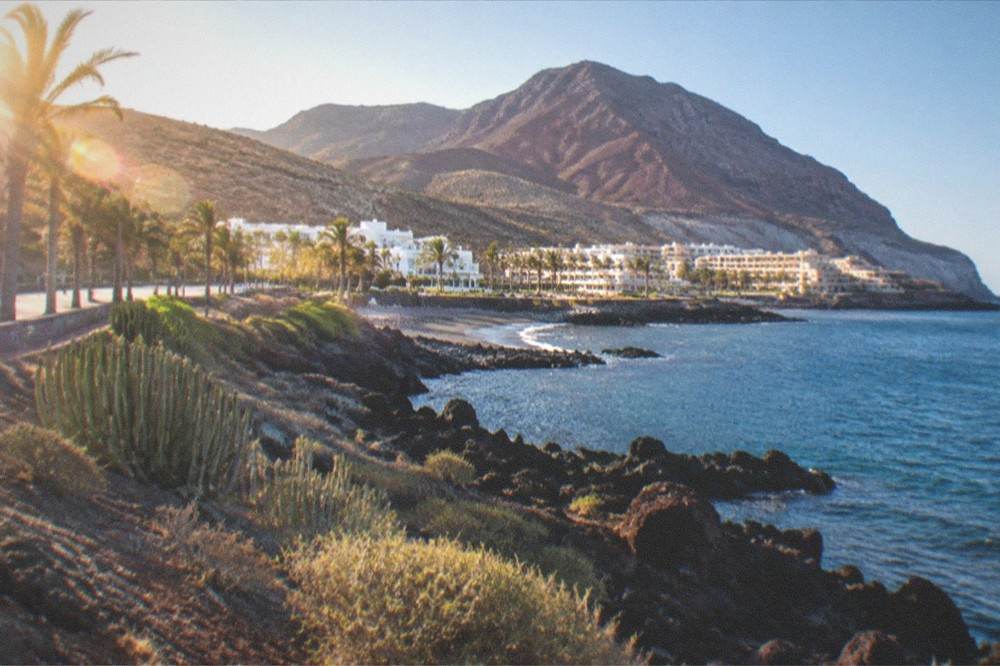 A volcanic mountainside of red and grey rock under a clear blue sky