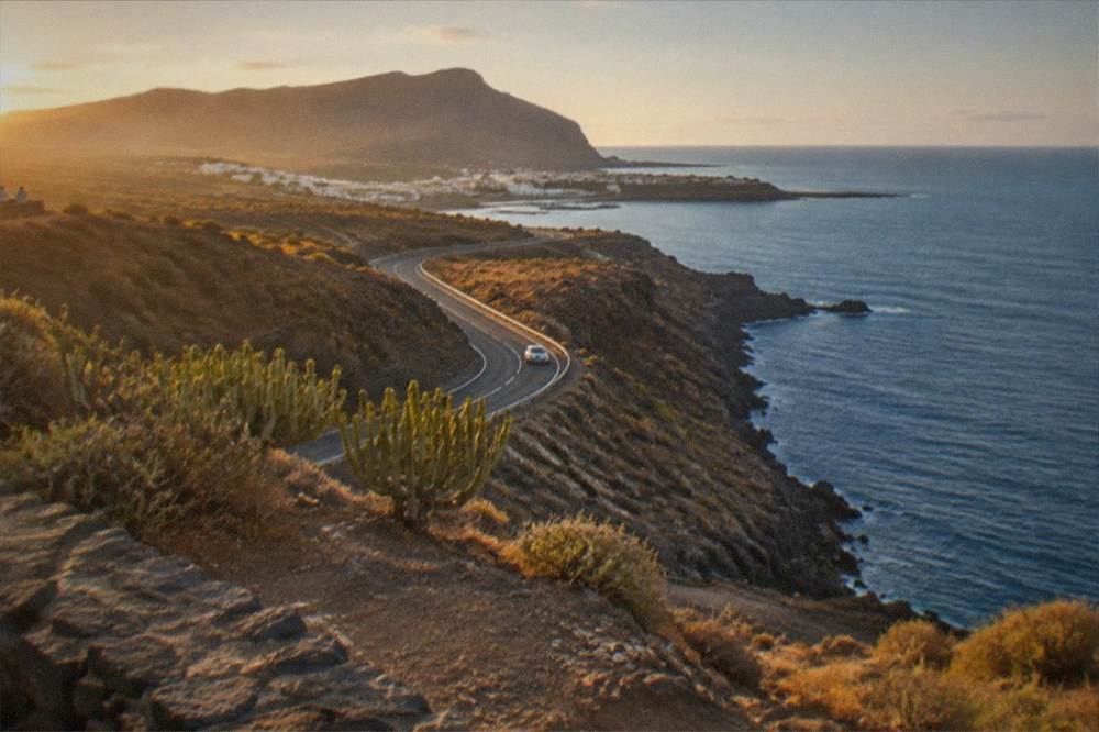 A winding coastal road with cliffs and the ocean seen from a viewpoint in west Tenerife