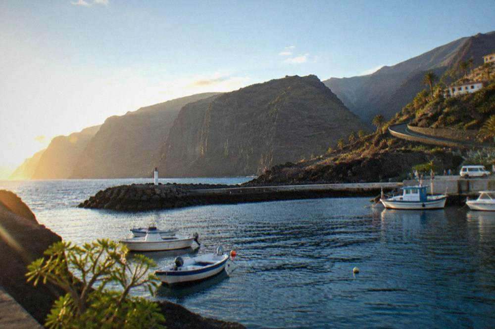 A small harbour on the west coast with boats moored beside dark rock