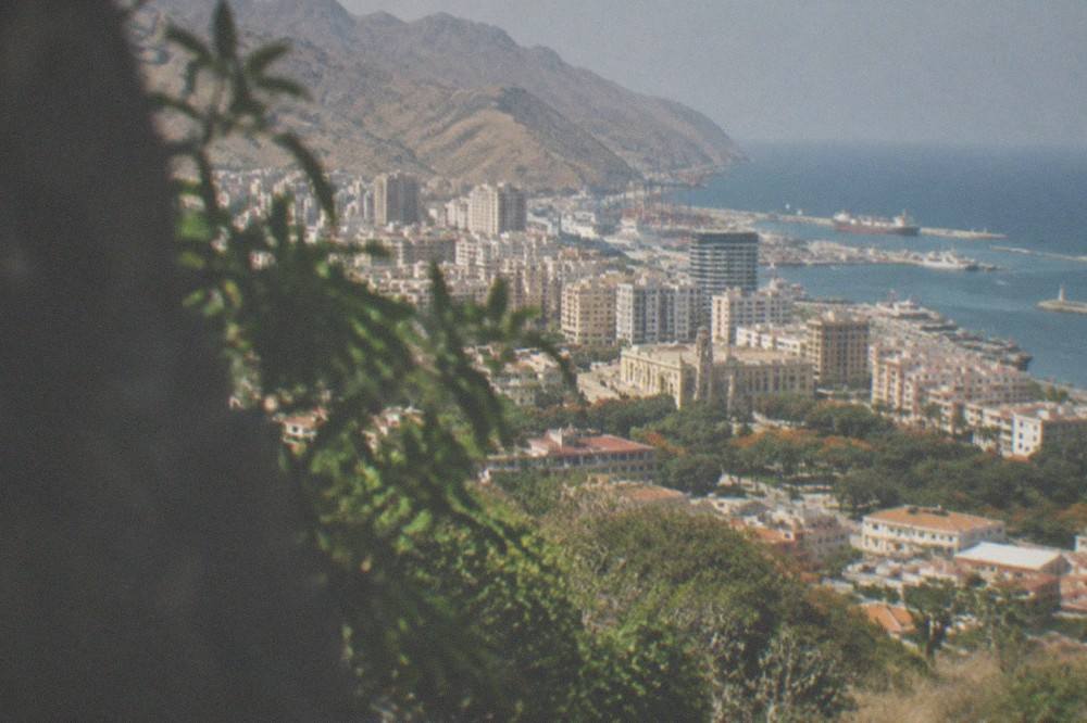 View from a green mountain ridge over rooftops and the sea near Santa Cruz
