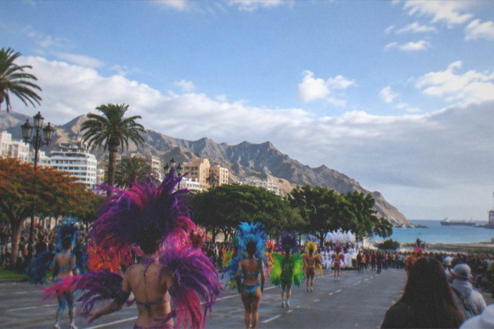 Crowded street with costumed performers at a carnival parade
