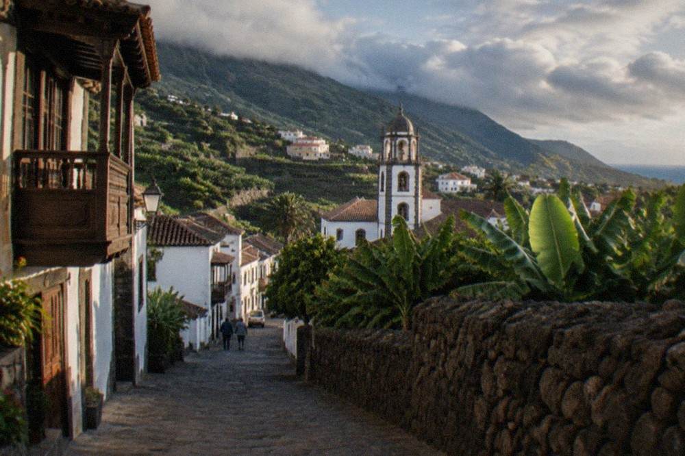 A small Canarian town with white houses and a church tower set among green hills