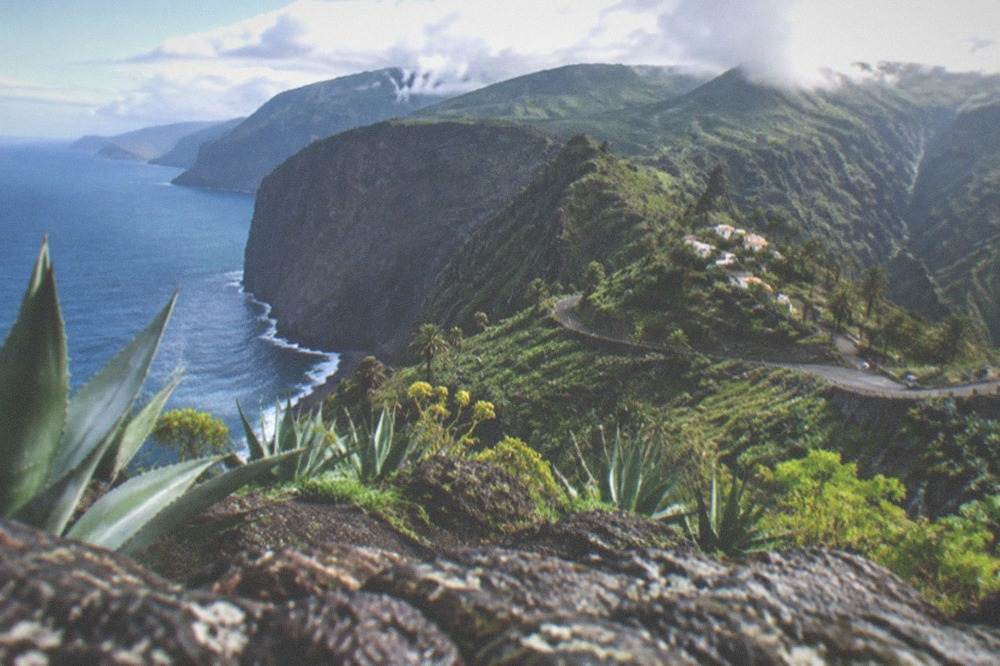 Clouds resting on green mountain ridges above the Teno coast