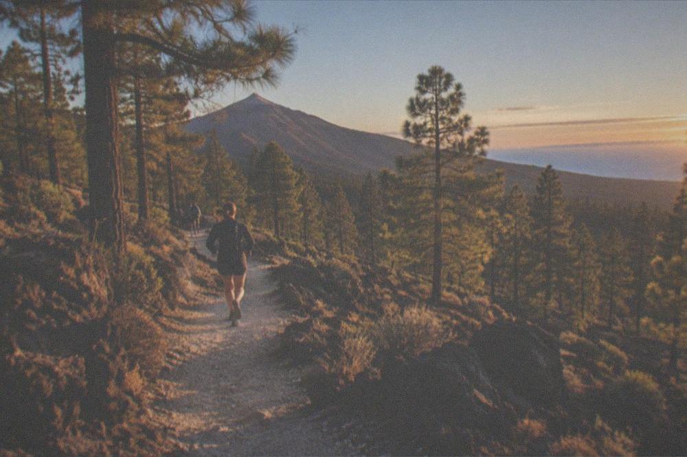 A marked footpath of pale volcanic gravel climbing between dark rock formations