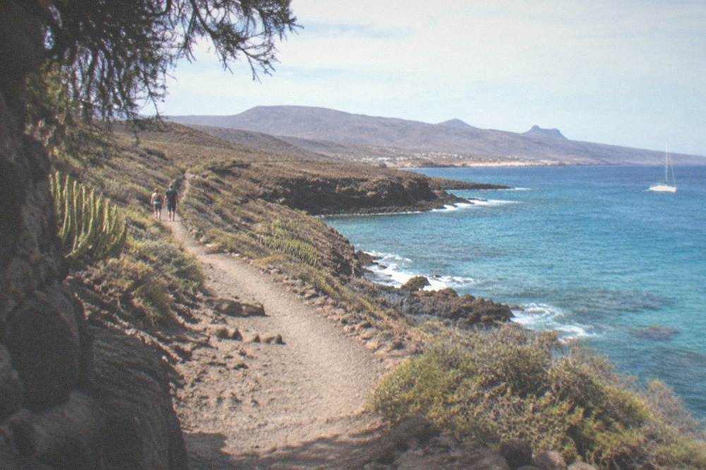 A coastal path beside turquoise water on Tenerife's dry southeast coast