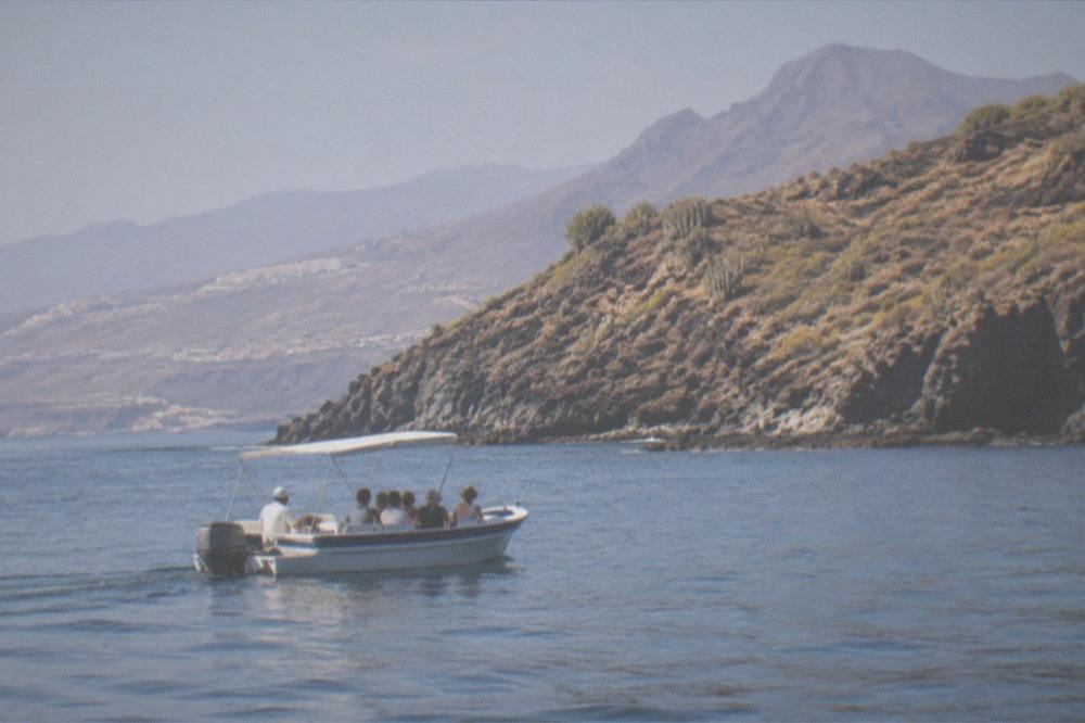 A small boat with passengers on a calm sea near the Tenerife coast
