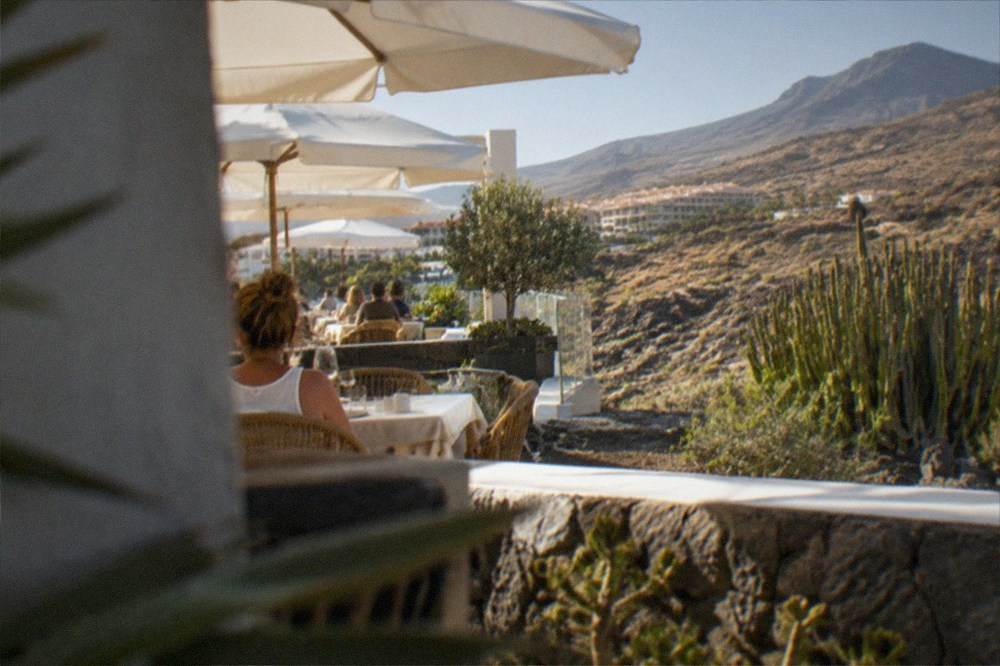 A terrace restaurant with white parasols near the sea in a Tenerife resort town