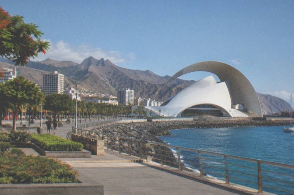 The Auditorio's white arch framed by blue sky and sea