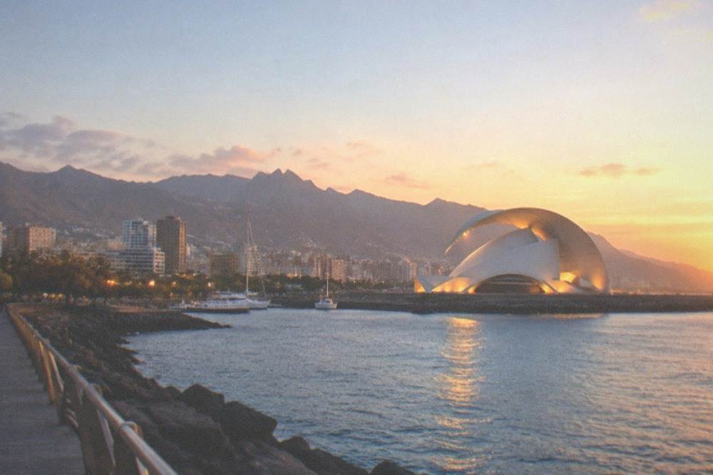 The Auditorio at dusk lit by floodlights beside the water