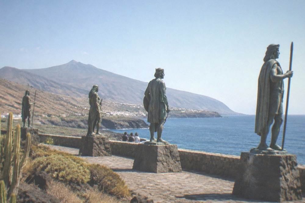 Bronze statues of the Guanche kings standing in a row beside the sea