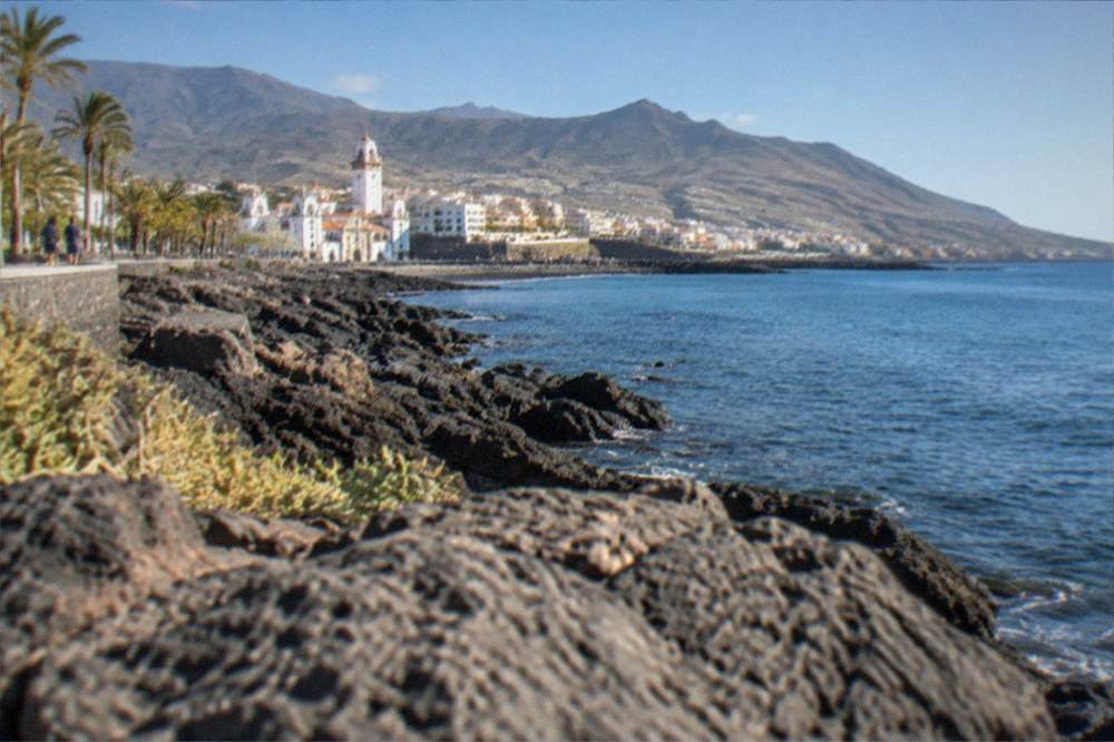 Sunlight over the seafront at Candelaria with calm water along the shore