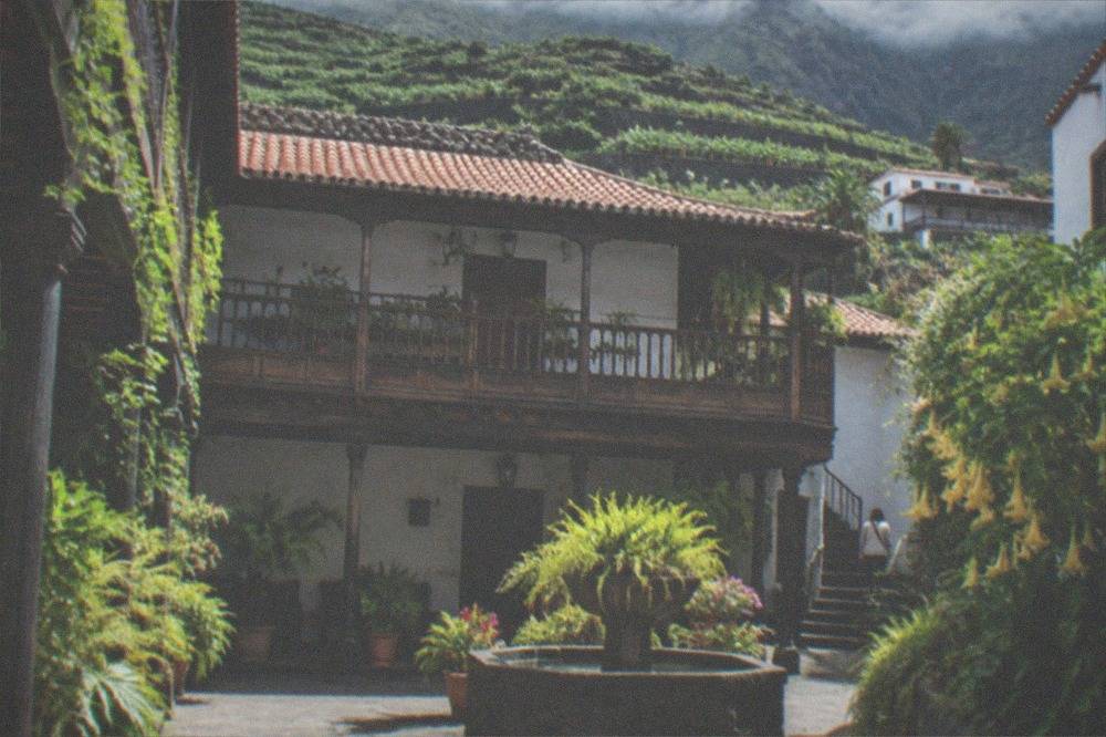 An interior courtyard of a traditional Canarian house with plants and wooden galleries