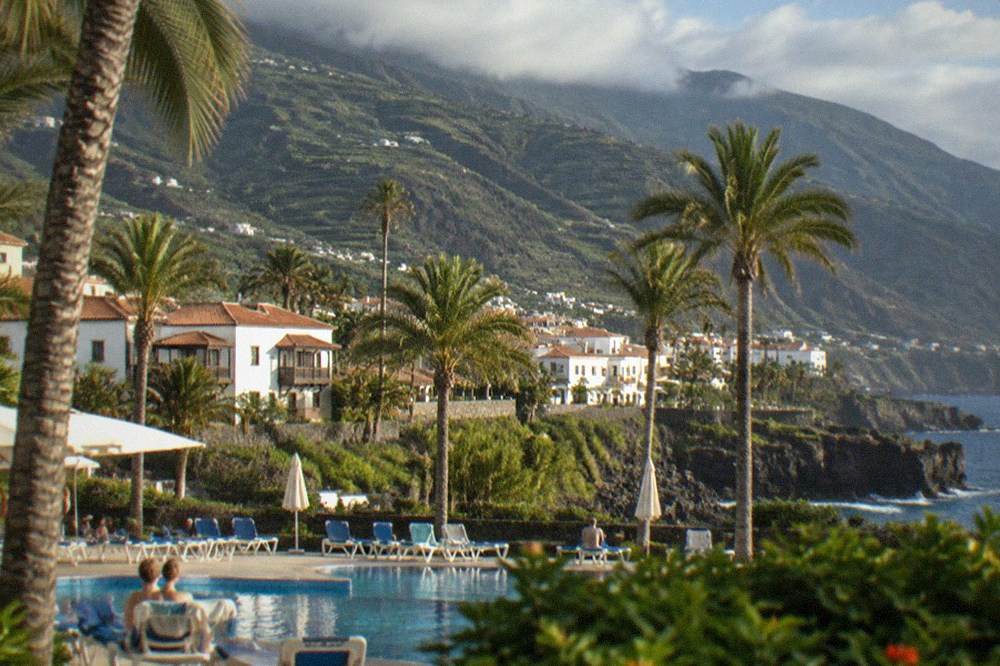 Sun loungers and palm trees around a lido pool in Puerto de la Cruz
