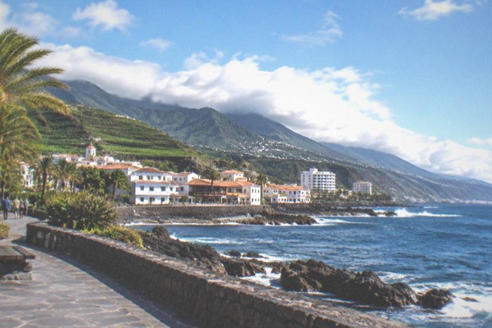 Clouds over green hills behind the rooftops of Puerto de la Cruz