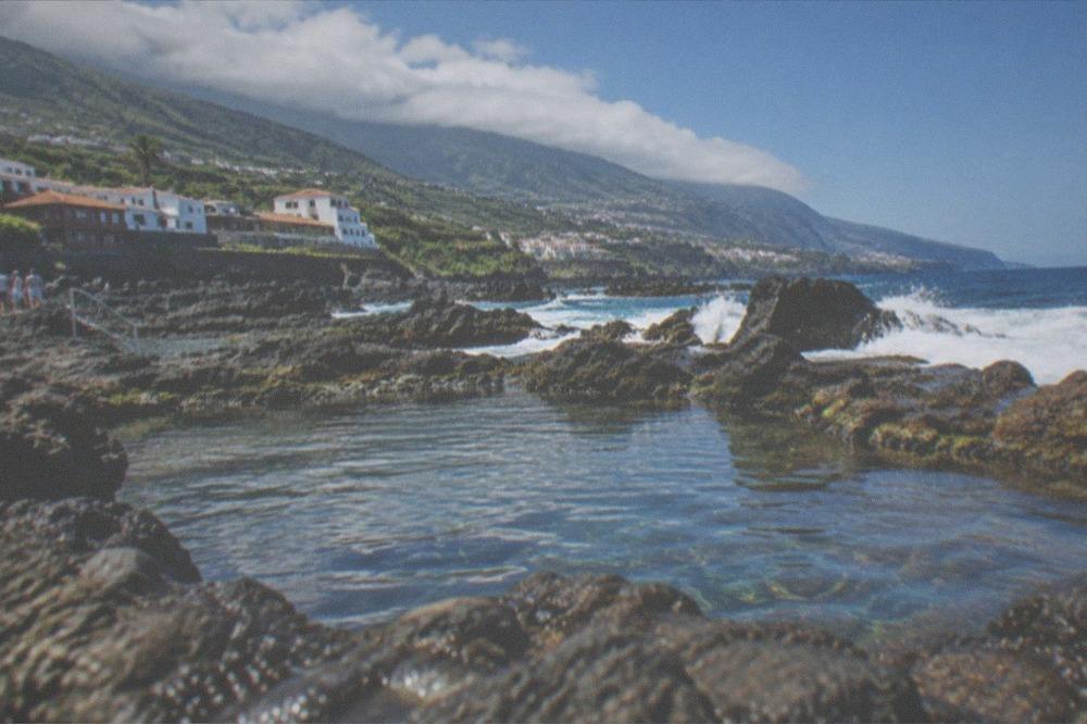 Volcanic rock pools along the north coast of Tenerife with waves behind