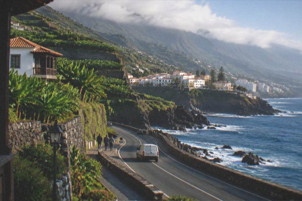 A coastal road winding between green hills and the sea in north Tenerife