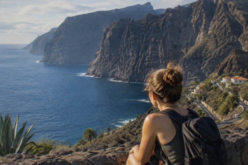 Tall dark cliffs rising straight out of calm blue sea on the coast of Tenerife