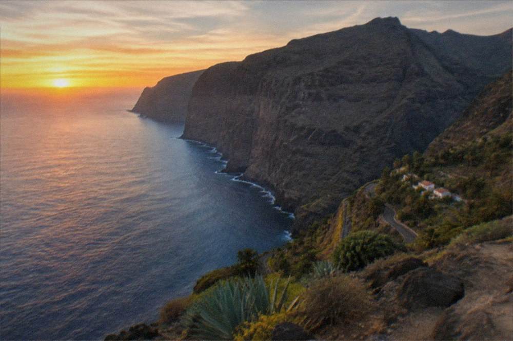 Sunset light on tall sea cliffs with a calm sea below