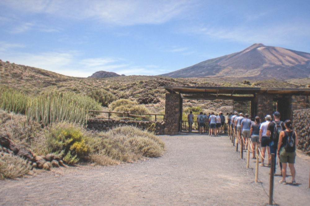 Visitors queueing at a park entrance gate in the morning