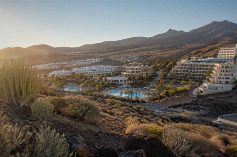 Aerial view of resort hotels and pools along the dry southern coastline
