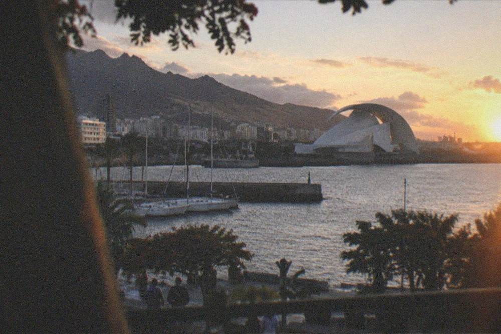 The white sail-shaped Auditorio de Tenerife beside the harbour at dusk