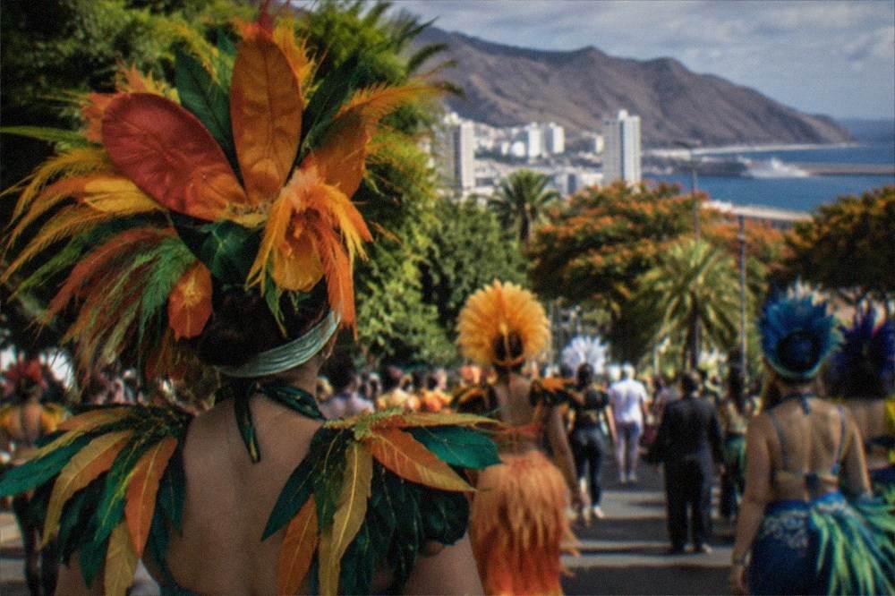 Crowds in costume filling a city street during a carnival celebration