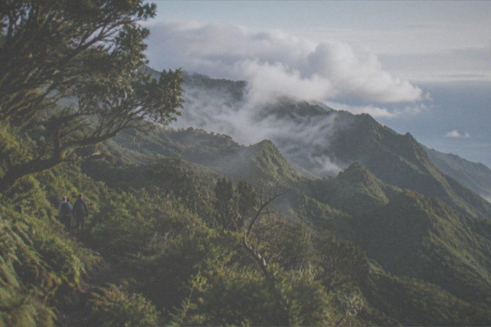 Clouds rolling over green mountain ridges above the Anaga coastline